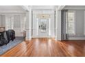 Bright foyer featuring hardwood floors, wainscoting, elegant trim, and a glass-paneled front door at 1754 Water Springs Way, Dacula, GA 30019