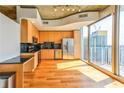 Modern kitchen featuring stainless steel appliances, wood cabinets, and a black backsplash, with an adjacent outdoor view at 860 Peachtree Ne St # 2716, Atlanta, GA 30308