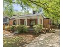 Brick home featuring covered front porch, walkway, and mature tree shade at 1700 John Calvin Ave, Atlanta, GA 30337