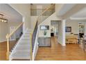 Welcoming foyer with staircase, hardwood floors, and views into the living spaces at 302 Wickley Way, Woodstock, GA 30188