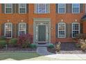 Close-up of a home's front door and entryway, showcasing brick facade and manicured landscaping at 302 Wickley Way, Woodstock, GA 30188