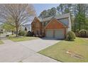 Attractive two-story home with a brick facade, a well-manicured lawn, and a double car garage at 302 Wickley Way, Woodstock, GA 30188