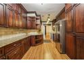 Traditional kitchen features dark wood cabinetry, granite countertops, and stainless steel appliances at 45 Willow Ne Gln, Atlanta, GA 30342