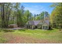 Picturesque home with lush green lawn and a storage shed, surrounded by mature trees at 285 Willow Shoals Dr, Covington, GA 30016
