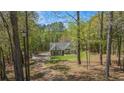 Scenic view of a charming home nestled among mature trees with a winding driveway at 285 Willow Shoals Dr, Covington, GA 30016
