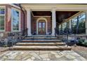 Stone steps lead to an inviting covered porch with elegant columns and a warm wood ceiling at 4505 Whitestone Way, Suwanee, GA 30024