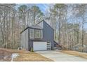 Unique home with modern design with large windows and garage door on a large lot surrounded by trees at 3214 Cedar Bluff Ne Dr, Marietta, GA 30062