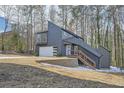 Unique exterior elevation showcases creative architecture with wooden stairs and a modern garage door with minimalist window design at 3214 Cedar Bluff Ne Dr, Marietta, GA 30062