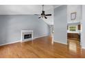 Open living room featuring a fireplace, hardwood floors, and access to the kitchen area at 3898 Hadley Farm Dr, Marietta, GA 30066