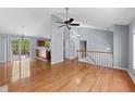 Open concept living room with hardwood floors, leading to kitchen and a staircase at 3898 Hadley Farm Dr, Marietta, GA 30066