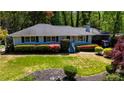 A ranch-style house with a manicured front yard, flower bushes, and a carport at 4519 Sims Ct, Tucker, GA 30084