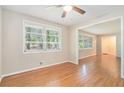 Bright living room featuring a ceiling fan, hardwood floors, and large windows at 2480 Warwick Ne Cir, Atlanta, GA 30345