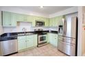 Well-lit kitchen with stainless steel appliances, light green cabinets, and dark countertops at 4992 Meadow Ln, Marietta, GA 30068