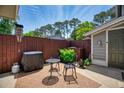 Relaxing patio with a grill, table and chairs, surrounded by a wooden fence and green foliage at 4992 Meadow Ln, Marietta, GA 30068