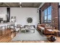 Spacious living room featuring exposed brick, concrete ceilings, and hardwood floors at 3235 Roswell Ne Rd # 721, Atlanta, GA 30305