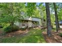Exterior view of home featuring a wooden porch, bench, and natural, wooded surroundings at 4553 Pond Ln, Marietta, GA 30062