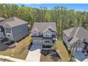 Aerial view of a gray home with stone accents, surrounded by green trees and neighboring homes at 5382 Pebblebrook Se Ln, Mableton, GA 30126