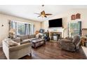 The living room features hardwood floors, a fireplace, sofas, chairs, and a ceiling fan at 126 Amberwood Ln, Euharlee, GA 30145