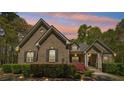 Charming brick home featuring a well-manicured lawn and mature landscaping at dusk at 45 Harvey Ave, Covington, GA 30016