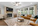 Cozy living room featuring a stone fireplace, large windows, hardwood floors, and stylish furniture at 185 Vandiver Ct, Acworth, GA 30101