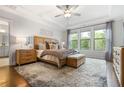 Serene main bedroom with tray ceiling, large windows, hardwood floors, and elegant furnishings at 185 Vandiver Ct, Acworth, GA 30101