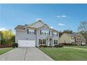 Traditional two-story home boasts a long driveway and a lush green lawn on a sunny day at 4528 Venus Sw Ct, Powder Springs, GA 30127