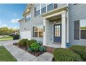 Inviting front entrance with a well-kept garden, gray siding, and a modern blue door at 4528 Venus Sw Ct, Powder Springs, GA 30127