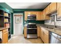 Functional kitchen featuring stainless steel appliances, light brown cabinets, granite countertops, and an exterior door at 1355 Euclid Ne Ave # 15A, Atlanta, GA 30307
