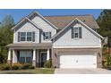 Beautiful two-story home with gray siding, brick accents, and a two-car garage. Includes a basketball hoop on the side of the driveway at 2034 W Hampton Dr, Canton, GA 30115