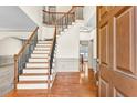 Spacious foyer featuring hardwood floors, elegant staircase, and neutral paint at 2424 Malden Park Dr, Buford, GA 30519