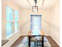 Bright dining room featuring a unique wood table, modern light fixture, and large windows at 3495 Delegate Aly, Scottdale, GA 30079