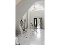 Elegant foyer with a crystal chandelier, marble flooring, and a curved staircase, showcasing luxurious details at 725 Riley Pl, Atlanta, GA 30327