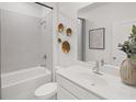 Modern bathroom featuring a bathtub, sleek vanity with a large mirror, tiled walls, and decorative gold accents at 1407 Bluffs Ridge Way, Canton, GA 30114