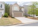 Tan two-story home with a two-car garage and a tidy front yard with fresh mulch at 275 Denver Ave, Hiram, GA 30141