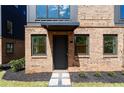Up-close view of brick home with landscaped entryway and a modern black front door at 1123 W Marietta St, Atlanta, GA 30318