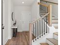 Bright foyer featuring hardwood floors, a staircase with black railings, and modern decor at 1123 W Marietta St, Atlanta, GA 30318