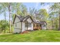A charming single-story house on a green lawn featuring a cozy porch, perfect for outdoor relaxation at 639 Ladora Dr, Dallas, GA 30157