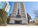 Low angle shot of the condo building with arched balconies, and a covered parking entrance at 2161 Peachtree Ne Rd # 605, Atlanta, GA 30309
