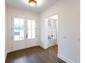 Bright foyer with double glass doors, dark hardwood floors, and neutral wall paint at 6565 Rhett Run, Cumming, GA 30028