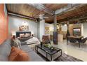 Spacious living space featuring exposed brick, wooden ceiling, comfortable seating, and a modern kitchen, blending comfort and style at 170 Boulevard Se # E006, Atlanta, GA 30312