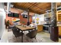 Open living space with exposed brick, wooden ceiling, dining area, and modern kitchen appliances, ideal for flexible living at 170 Boulevard Se # E006, Atlanta, GA 30312