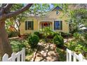 Charming yellow home with lush landscaping, red door and brick pathway at 218 Barry St, Decatur, GA 30030