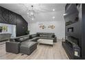 A living room showcasing a large gray sectional sofa, herringbone accent wall, and modern light fixture at 295 Hollyberry Dr, Roswell, GA 30076