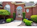 Inviting front entrance with decorative glass door and manicured landscaping at 4955 Kingsbridge Ct, Powder Springs, GA 30127