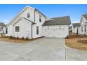 Spacious white two-car garage with extra-wide driveway and simple, elegant exterior lighting at 535 Pearl St, Cumming, GA 30040