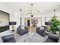 Comfortable living space featuring armchairs, modern chandelier, and view of dining area with bar at 3475 Oak Valley Ne Rd # 1720, Atlanta, GA 30326