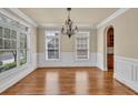 Elegant dining room with hardwood floors, wainscoting, large windows and chandelier at 3810 Baverton Dr, Suwanee, GA 30024