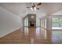 Spacious living room with hardwood floors, a brick fireplace, large windows, and a vaulted ceiling at 5894 Highway 20 Ne, Cartersville, GA 30121