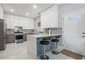 Modern kitchen with white cabinets, stainless steel appliances, and a marble island at 4505 Lakefield Bnd, Berkeley Lake, GA 30096