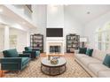 Staged living room featuring high ceilings, large windows, a fireplace, and stylish furniture at 4505 Lakefield Bnd, Berkeley Lake, GA 30096